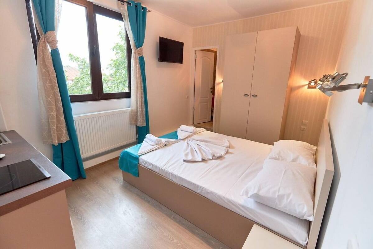 Ein Schlafzimmer mit einem Bett, einem Schreibtisch, einem Fernseher und einem Kleiderschrank.