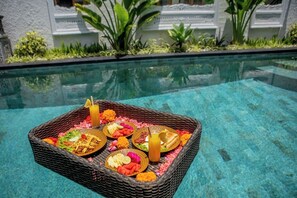 Una piscina al aire libre, sombrillas, sillones reclinables de piscina