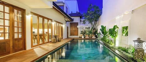 Een buitenzwembad, parasols voor strand/zwembad