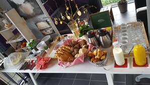 A breakfast buffet with various breads, pastries, and beverages. - B&B Bovenweg (Rhenen)