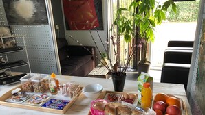 A breakfast table with various food items and a potted plant. - B&B Bovenweg (Rhenen)