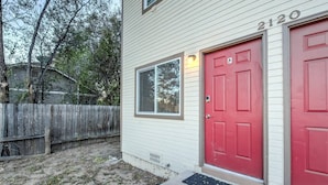 A single-story house with a red door, a window with blinds, and a mailbox. - 2BR Garden of the Gods Hike, Dine, Nightlife! (Colorado Springs)