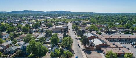 An aerial view of a town with residential houses, a main road, and a large industrial building.