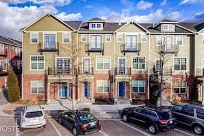 A row of townhouses with a parking lot in front.