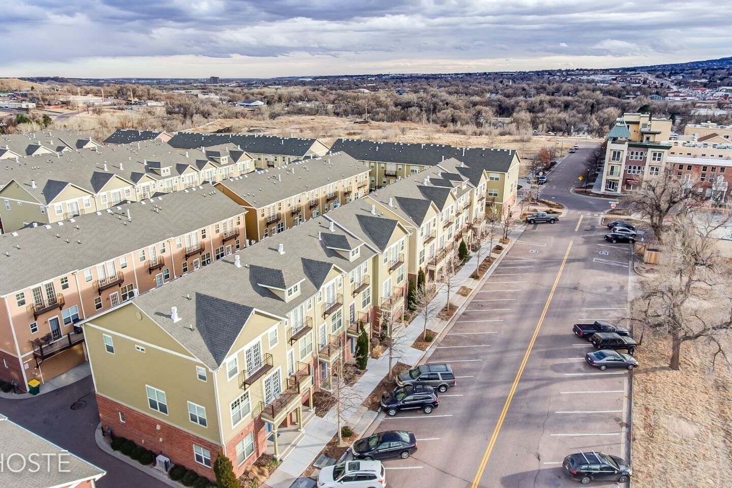 A row of townhouses with a parking lot in the foreground.