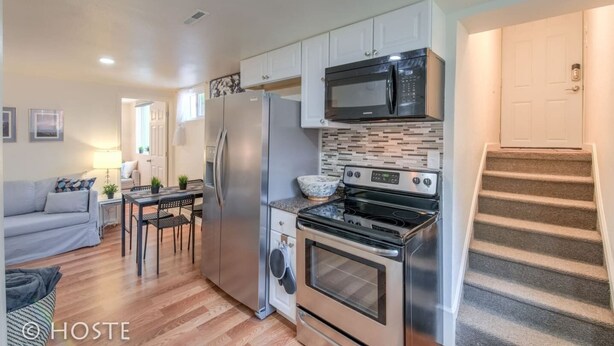 A compact kitchen with a refrigerator, microwave, oven, and stove. There is a dining area with a table and chairs.