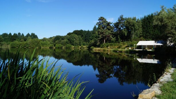 A serene lakeside setting with a white gazebo by the water. - Moulin de Lachaud (Sainte-Fortunade)