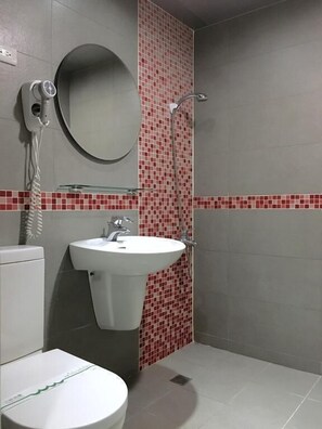 A bathroom with a toilet, sink, and shower. - Wan Tai Hotel (Chiayi City)