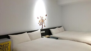 Une chambre d’hôtel avec deux lits, une table de chevet, une lampe et un élément décoratif mural.