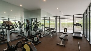 A modern gym with various exercise equipment, large windows, and a clean, spacious layout. - Pacific Residence 39 (Bangkok)