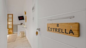 A hallway with a wooden door labeled "2 Estrella" and a television screen displaying "NETFLIX". - Blue Mountain Guesthouse "Estrella” (Arachova)