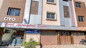 Hotel Aurangabad Regency med en moderne facade, et reception område og et skakternet fortov foran.