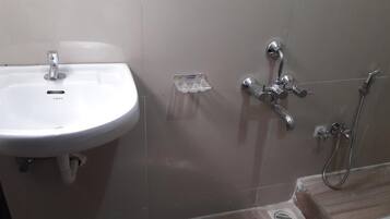 A bathroom with a white sink, a shower, and a toilet.
