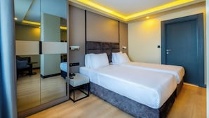 A modern hotel room with a large bed, bedside tables, a desk, and a mirror. - Frt Airlines Hotel - Istanbul Airport (Arnavutköy)