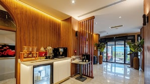 A reception area with a wooden panel wall, a counter with a coffee machine, and a refrigerator. - Frt Airlines Hotel - Istanbul Airport (Arnavutköy)