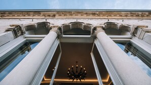 En imponerende, arkitektonisk indretning med høje søjler og en stor lysekrone i midten.