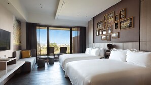 A hotel room with two large beds, a TV, a balcony with a view, and a wall decorated with framed pictures. - Fame Hall Garden Hotel (Taoyuan City)