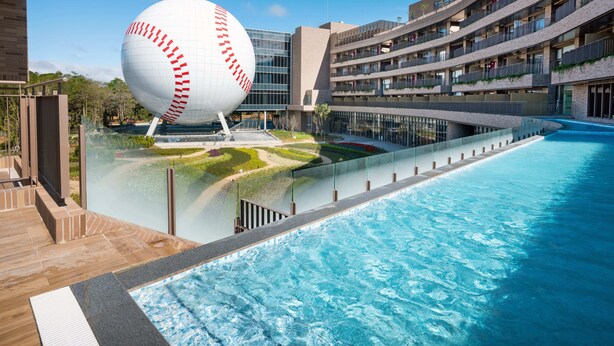 A modern hotel with a large swimming pool, a unique spherical sculpture, and a multi-story building with balconies. - Fame Hall Garden Hotel (Taoyuan City)