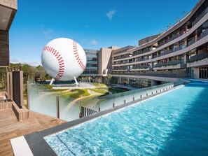A modern hotel with a large swimming pool, a unique spherical sculpture, and a multi-story building with balconies. - Fame Hall Garden Hotel (Taoyuan City)