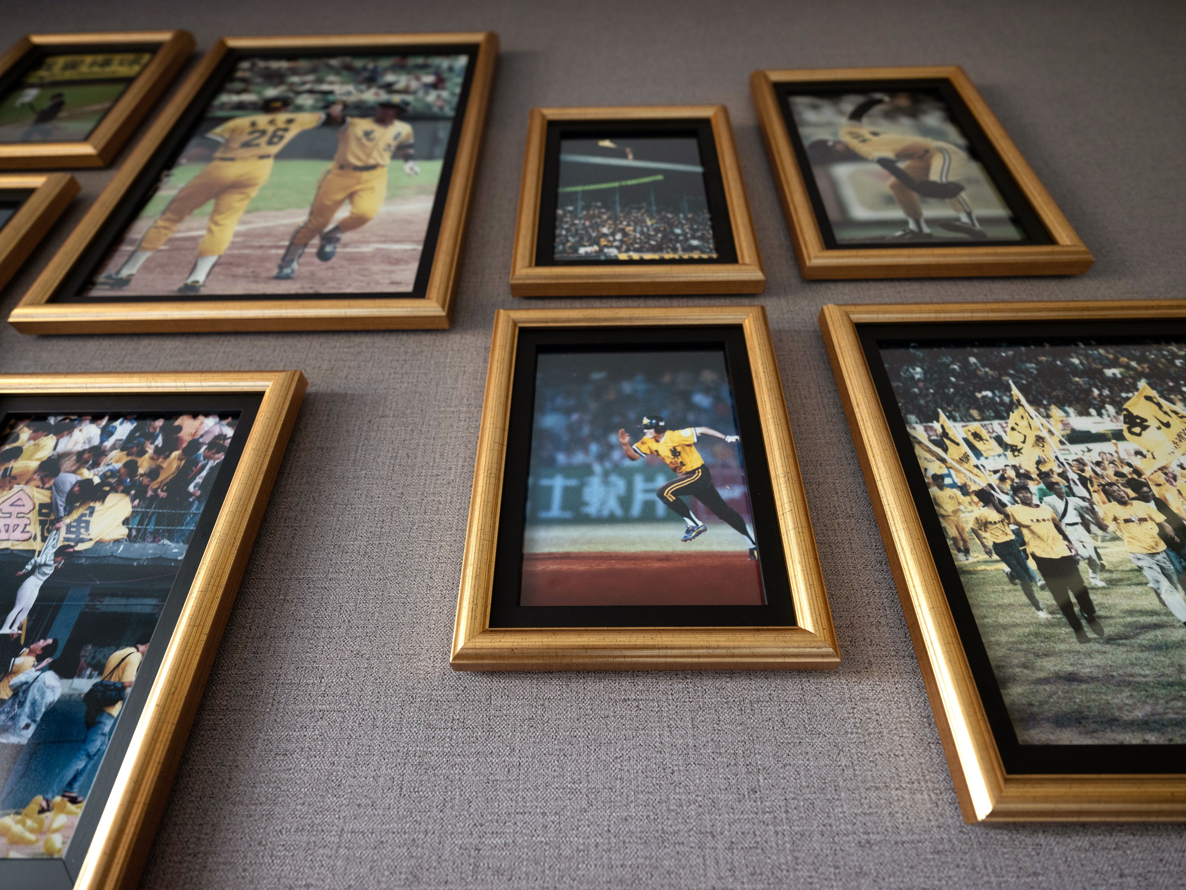 Una pared con varias fotografías enmarcadas de eventos deportivos.