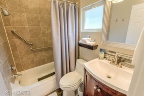 A bathroom with a bathtub, toilet, and sink.