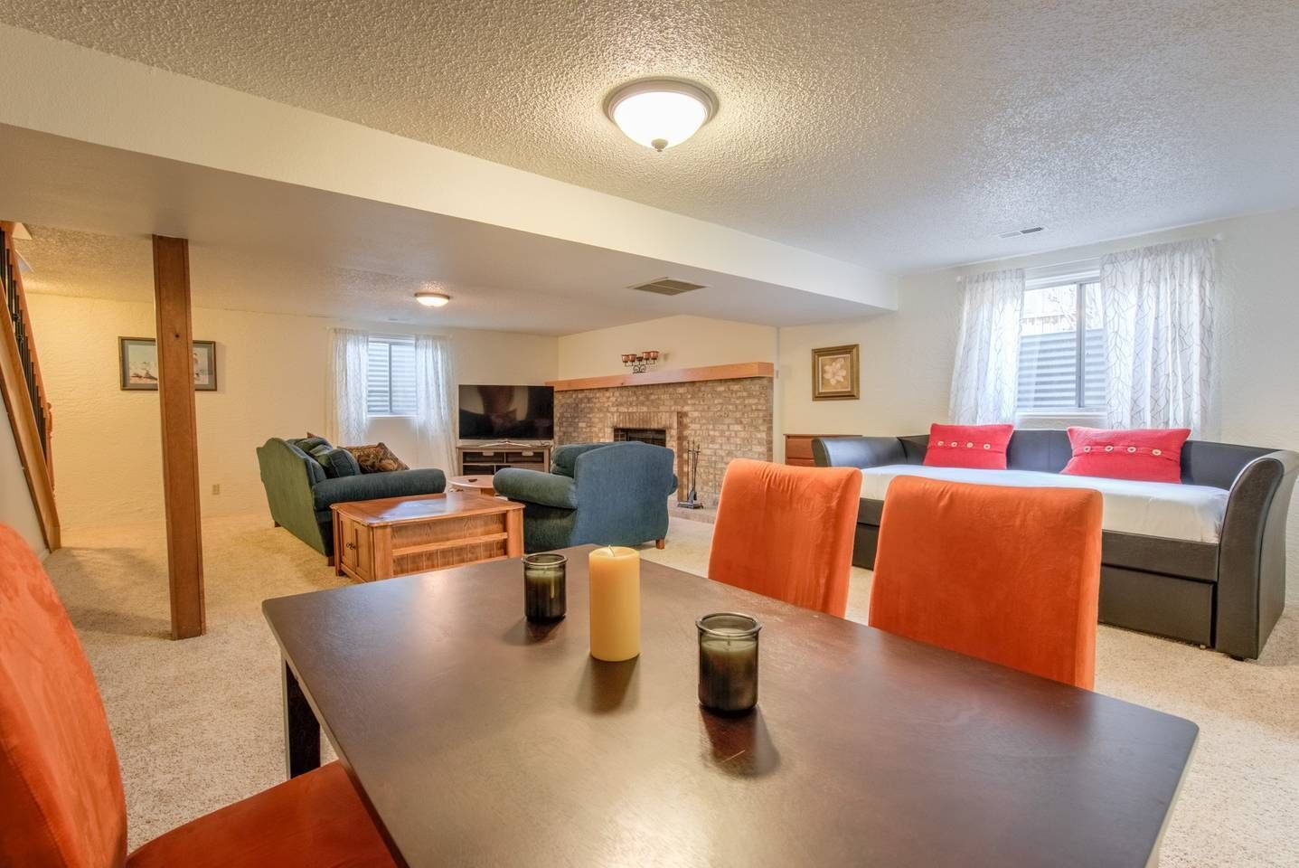 Una sala de estar con chimenea, televisor y comedor con mesa y sillas.