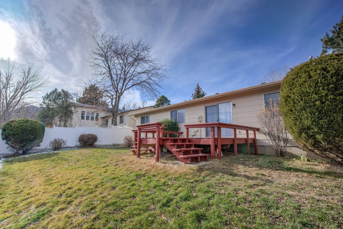 A single-story house with a covered porch and a small deck.