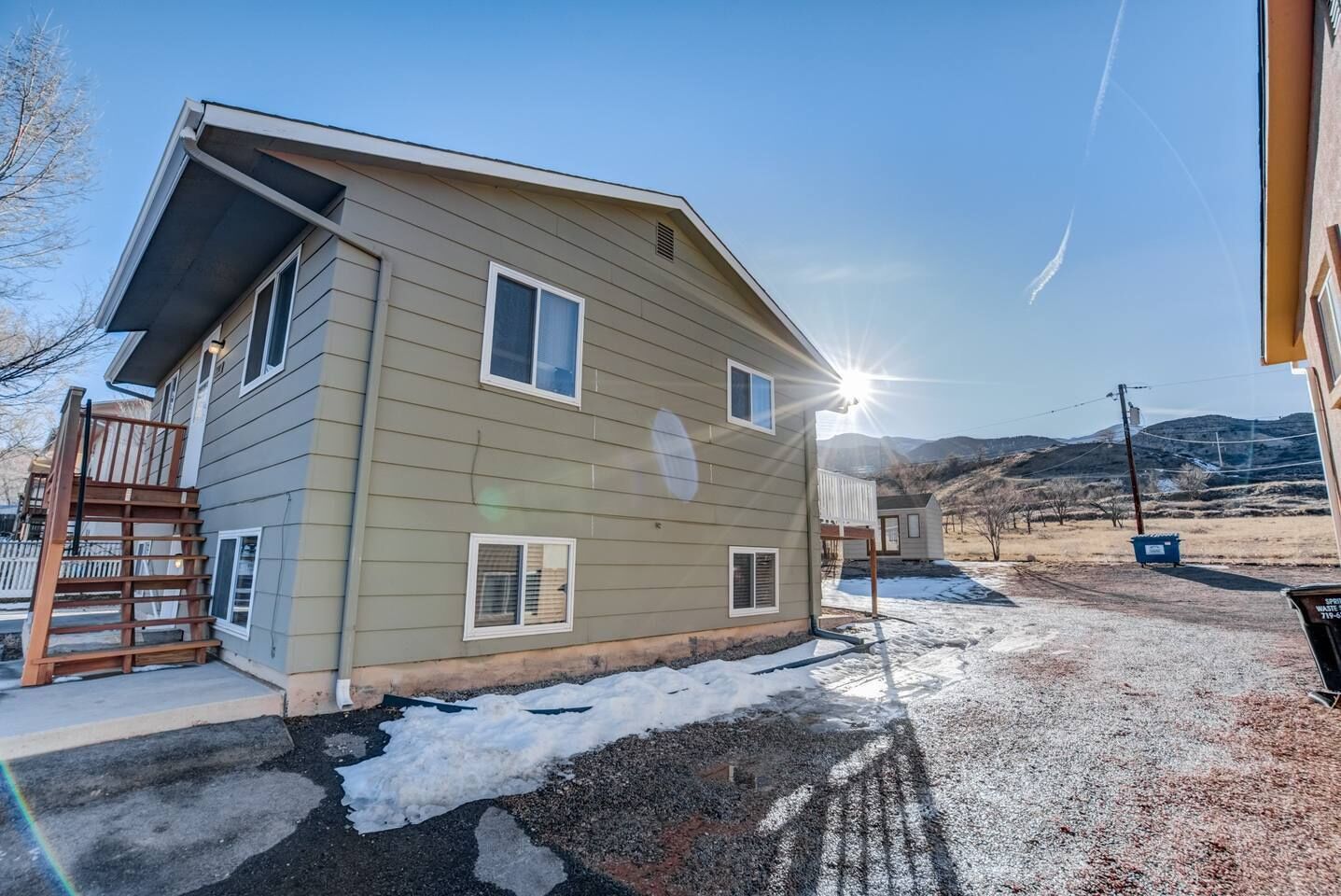 A two-story house with a front deck and a small attached garage.