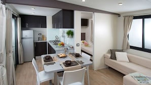 A compact living space with a kitchenette, dining area, and a sofa. - Agriturismo Ca' Vecia (Sona)