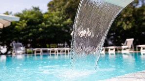 A clear view of a swimming pool with water flowing from a structure into it. - Agriturismo Ca' Vecia (Sona)