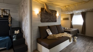 A cozy room with a bed, a small table with candles, and a wall-mounted sculpture. - Agriturismo Ca' Vecia (Sona)