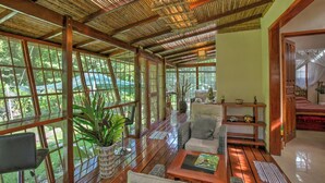 A spacious room with large windows, a wooden floor, and a ceiling with bamboo slats. - Zen Villa # 1 -  Three bedroom Luxury Villa with Private Garden -Playa Chiquita (Puerto Viejo de Talamanca)