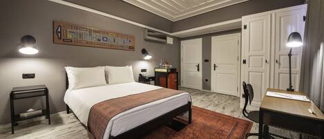 A bedroom with a bed, bedside tables, a desk, and a chair.