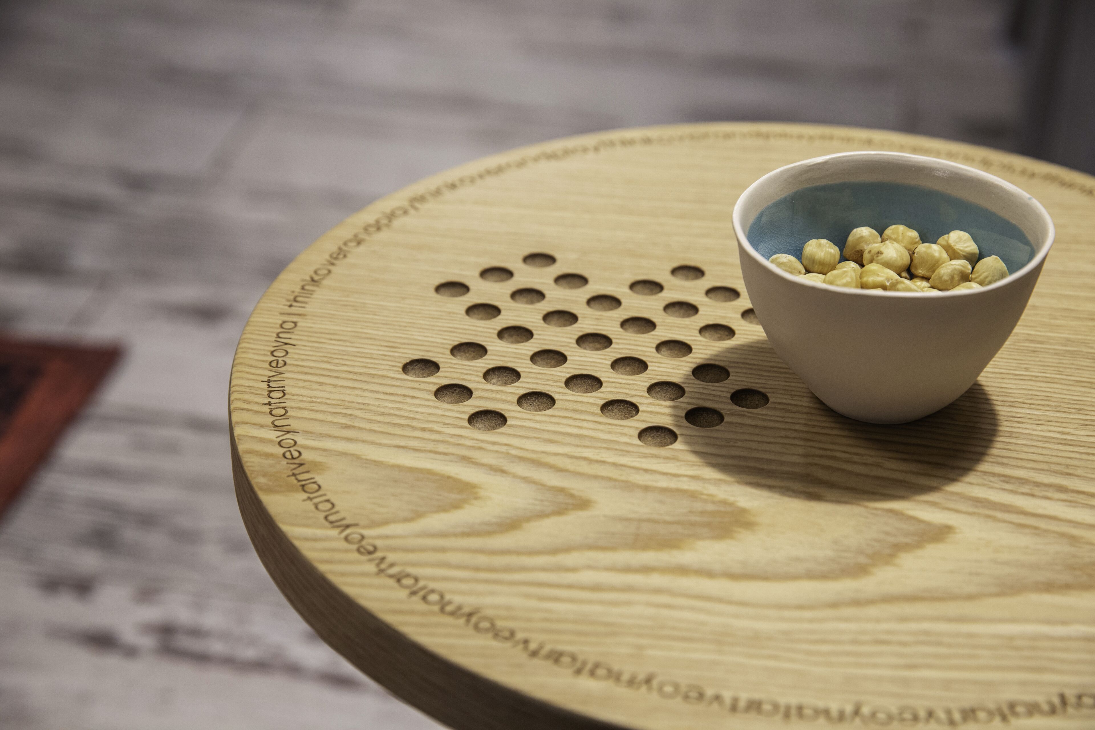 A wooden table with a bowl of chickpeas on it.
