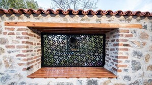A stone wall with a wooden bench and a decorative metal screen.