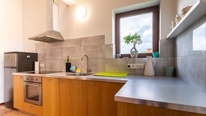 A modern kitchen with a built-in oven, a sink, and a window with a view. - Victus Apartamenty - Cadena 1 (Sopot)