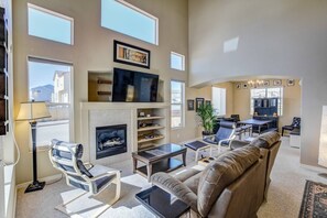 A spacious living room with a fireplace, a large flat-screen TV, and comfortable seating. - 3BR AF Academy Pet-friendly (Colorado Springs)
