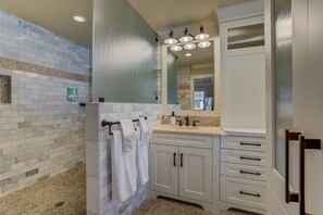 A bathroom with a shower, a vanity with a mirror, and a towel rack. - 5BR Mnt Viewsdowntown Luxuryfirepit & RV Parking (Colorado Springs)