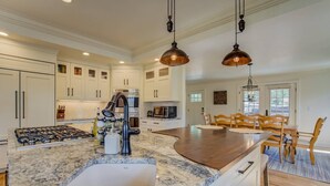 A modern kitchen with a granite countertop, stainless steel appliances, and pendant lighting. - 5BR Mnt Viewsdowntown Luxuryfirepit & RV Parking (Colorado Springs)