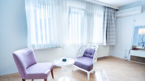 Una habitación moderna con dos sillas, una mesita redonda y un radiador.