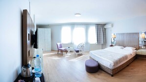 Una habitación de hotel con cama, escritorio, silla, armario y televisión.