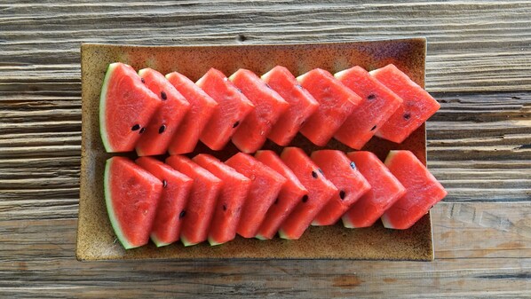 A plate of watermelon slices arranged in a grid pattern on a ceramic plate. - Sapa Mountain Eco Lodge (Sa Pa)