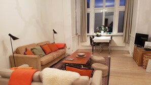 En moderne stue med sofa, sofabord og spiseområde.