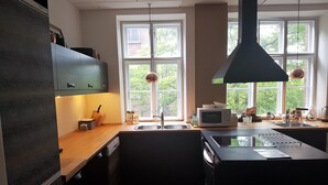 Et moderne køkken med en central ø, indbygget ovn, mikroovn og vask.