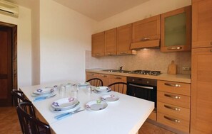 A modern kitchen with wooden cabinets, a white countertop, and a dining table set for four.