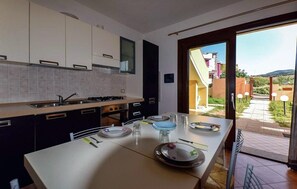Una cocina moderna con comedor, que cuenta con un amplio ventanal y vistas al exterior.