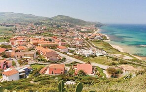 A coastal town with buildings along the beach and a view of the sea.