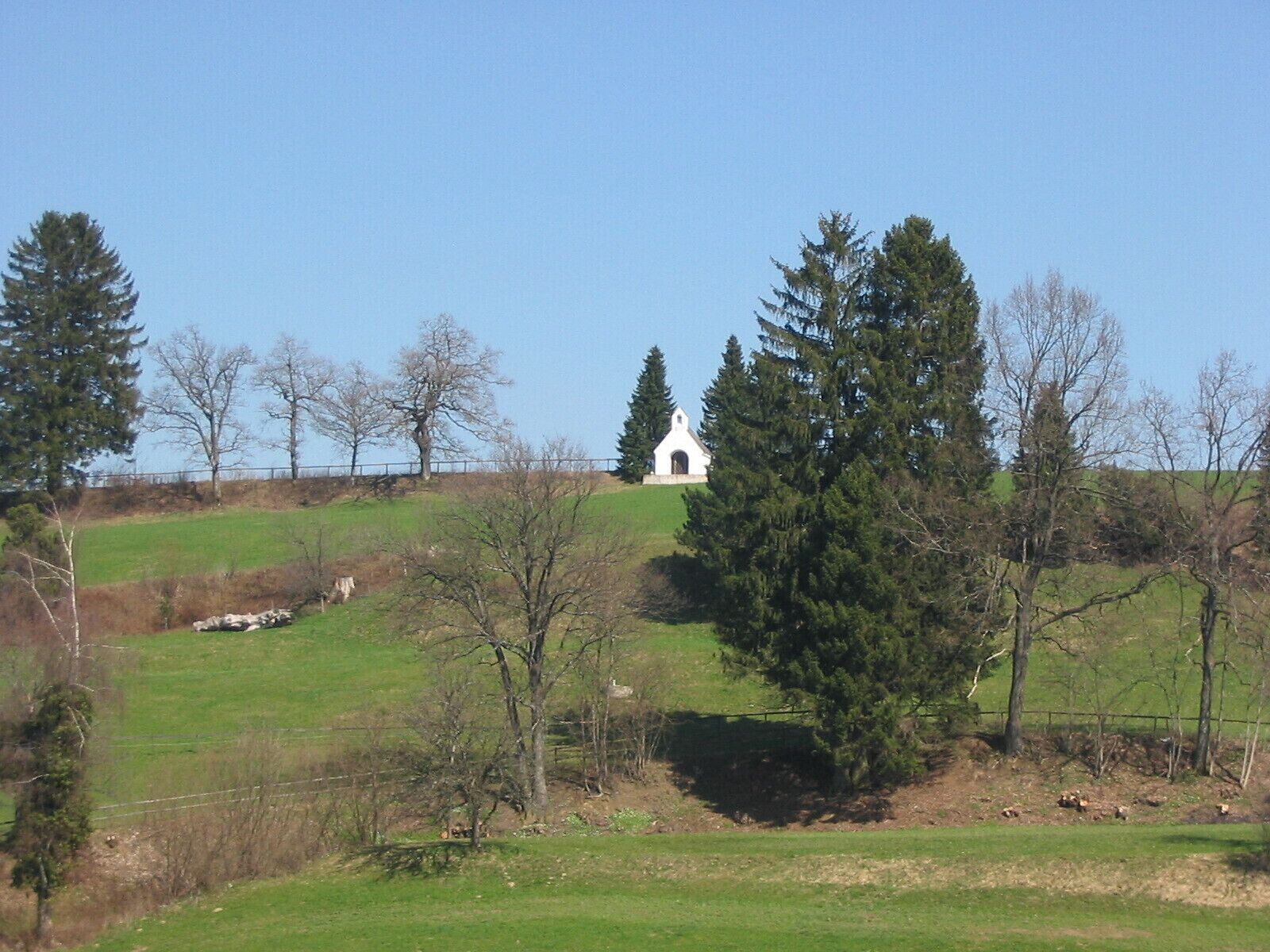 Une église blanche, perchée sur une colline, sous un ciel dégagé.
