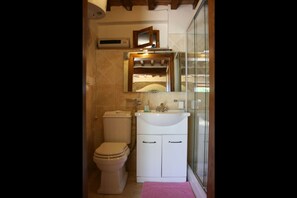 A small bathroom with a toilet, sink, and mirror. - La Casina del Bosco (Citerna)