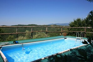 A swimming pool with a view of a forested landscape and mountains in the distance. - La Casina del Bosco (Citerna)